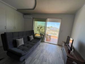 a living room with a couch and a large window at Ninou diamants in Harqalah