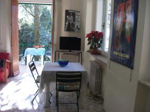 uma sala de jantar com uma mesa com cadeiras e uma televisão em B&B La Principessa em Corciano
