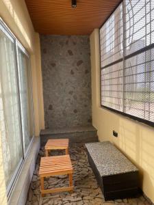 two wooden benches in a room with a window at Galle subalbe in Pikine