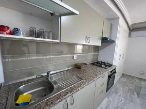 a kitchen with a sink and a stove at Ninou diamants in Harqalah