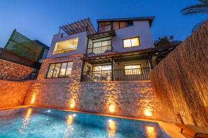 a house with a swimming pool in front of a building at Villa Elfuze in Kalkan