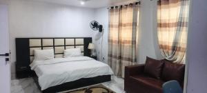 a bedroom with a bed and a couch at Wavelength Hotel and uites in Ibadan