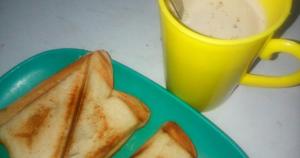 a green plate with a sandwich and a cup of coffee at Wavelength Hotel and uites in Ibadan