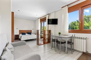 a living room with a table and a couch at Apartamentos Rurales & Spa Antilles Playa in Llanes