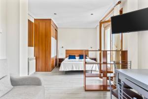 a bedroom with a bed with blue pillows at Apartamentos Rurales & Spa Antilles Playa in Llanes +69 photos
