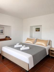 a bedroom with a large bed with slippers on it at Apartments Marina in Lopar