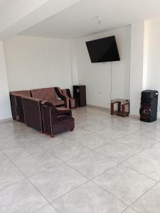 a living room with two chairs and a flat screen tv at Casa Rústica Diaz in Ica