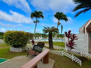 a park with a bench and palm trees at Central and Bright 2 BR, 2 BA, Pool and Oceanview in Lihue