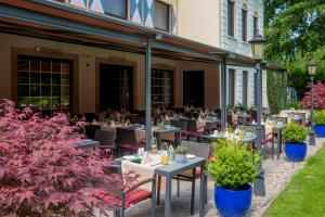 a restaurant with tables and chairs in front of a building at Parkhotel Hohenfeld Münster in Münster