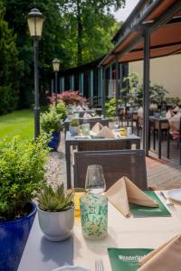 an outdoor table with chairs and a table with a glass at Parkhotel Hohenfeld Münster in Münster +34 photos