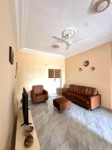 a living room with a couch and a tv at KMR Apartment - Sira in Sere Kunda +10 photos