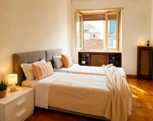 a bedroom with a large bed and a window at Quick Home Victoria in Biella