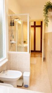 a bathroom with a sink and a toilet and a mirror at Quick Home Victoria in Biella