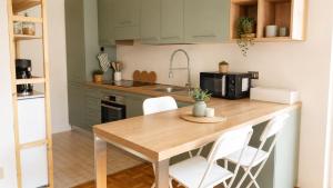 a kitchen with a wooden table and white chairs at Quick Home Victoria in Biella