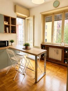 a kitchen with a table and two chairs at Quick Home Victoria in Biella +9 photos