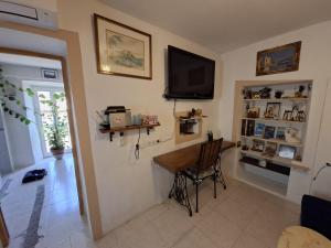 a living room with a table and a television on the wall at Merozzini in Moltifao