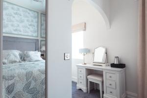 a bedroom with a bed and a desk with a mirror at Cloonacauneen Castle in Galway