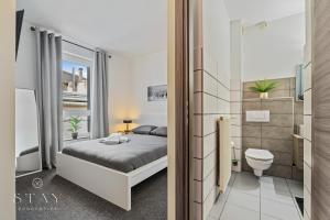 a small bedroom with a bed and a toilet at Hotel Stay Properties in Luxembourg