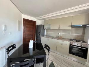 a kitchen with a table and a stove and a refrigerator at Ninou diamants in Harqalah