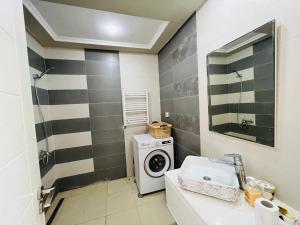 a bathroom with a washing machine and a washer at Ninou diamants in Harqalah
