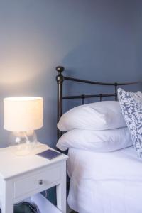 a bed with white pillows and a lamp on a table at The Green Man in Dunchurch