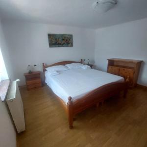 a bedroom with a large bed with white sheets at Villa Mezzo in Paularo