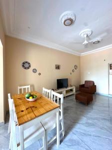 a dining room with a table and a living room at KMR Apartment - Sira in Sere Kunda