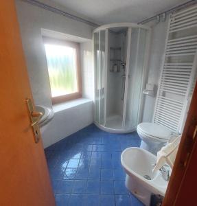 a bathroom with a shower and two toilets and a sink at Villa Mezzo in Paularo