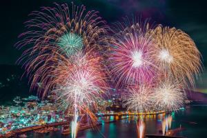 a firework display with a city in the background at Liminal in Atami