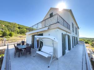 a balcony with a table and chairs and a building at Villa Petar Stone in Kamensko