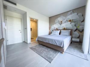 a bedroom with a bed with white flowers on the wall at Villa Petar Stone in Kamensko
