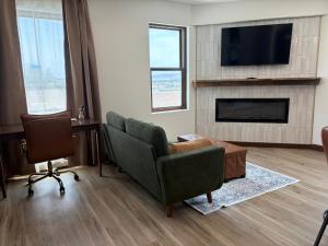 a living room with a tv and a couch and chairs at Historic Tomahawk in Green River