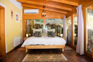 a bedroom with a bed and a large window at Erdei Kisház Sümeg in Sümeg