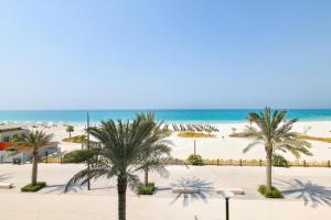 a view of the beach from the balcony of a resort at Aurora 1BR - Coastal Chic Luxe Retreat in Abu Dhabi