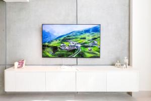 a white cabinet with a tv on a wall at Aurora 1BR - Coastal Chic Luxe Retreat in Abu Dhabi