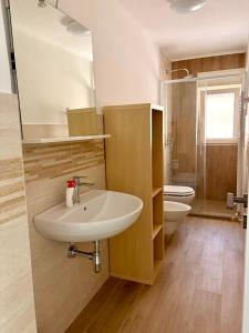 a bathroom with a sink and a toilet and a mirror at I Due Timidi in Putignano