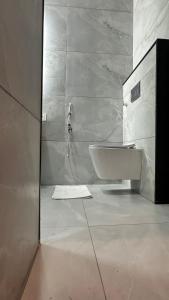a white bathroom with a sink and a shower at Aadyanta in Kadūr