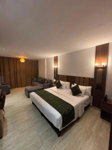 a bedroom with a large bed and a couch at Hôtel City Center in Nador