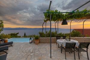 a patio with a table and chairs and a pool at Bol Cutie in Murvica