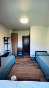 a room with two beds and a wooden floor at A lì dai Nûtis in Venzone