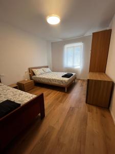 a small room with two beds and a window at A lì dai Nûtis in Venzone