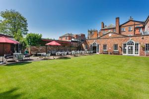 a large yard with tables and chairs in front of a building at The Wynnstay Hotel, Oswestry, Shropshire - The Coaching Inn Group in Oswestry
