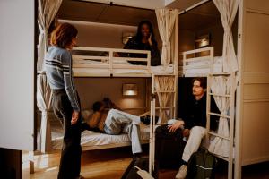 a group of people standing in a room with bunk beds at Wombat's City Hostel London in London