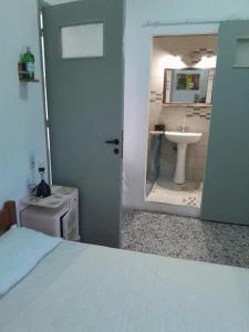 a bedroom with a bathroom with a sink and a bed at makis in Xilosírtis