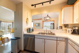 a kitchen with white cabinets and a sink at Knottaway - Duck, Sound Sea Village, Ocean View, 125 Yds to Beach, Pets OK, Flex Stays in Duck