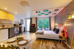 a kitchen and a bedroom with a bed in a room at Les Suites d'Orly, Évasion à 15 min de Paris in Orly