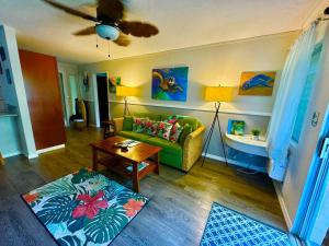 a living room with a green couch and a table at Ideal Coconut Coast Condo in Kapaa +87 photos
