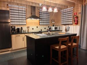a kitchen with a black counter and two chairs at MontHuit in Houffalize +27 photos