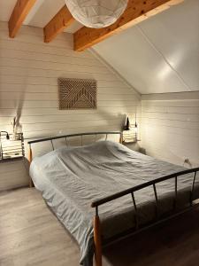 a bedroom with a bed in a room with white walls at MontHuit in Houffalize