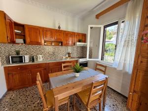 a kitchen with wooden cabinets and a table with chairs at Demie and George Ηouse in Loutraki